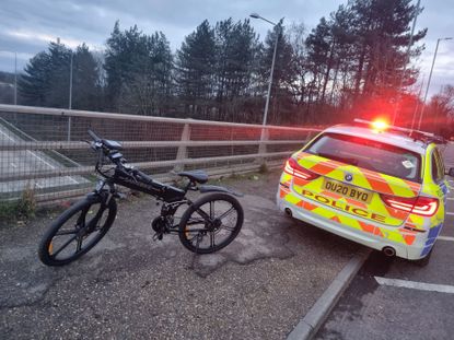 The e-bike next to a police car after being seized by police