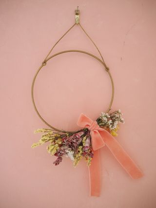 mini dried flower wreath on pink wall