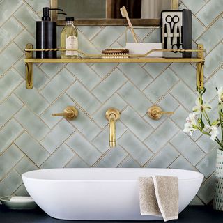 bathroom with brass fittings and iridescent tiling