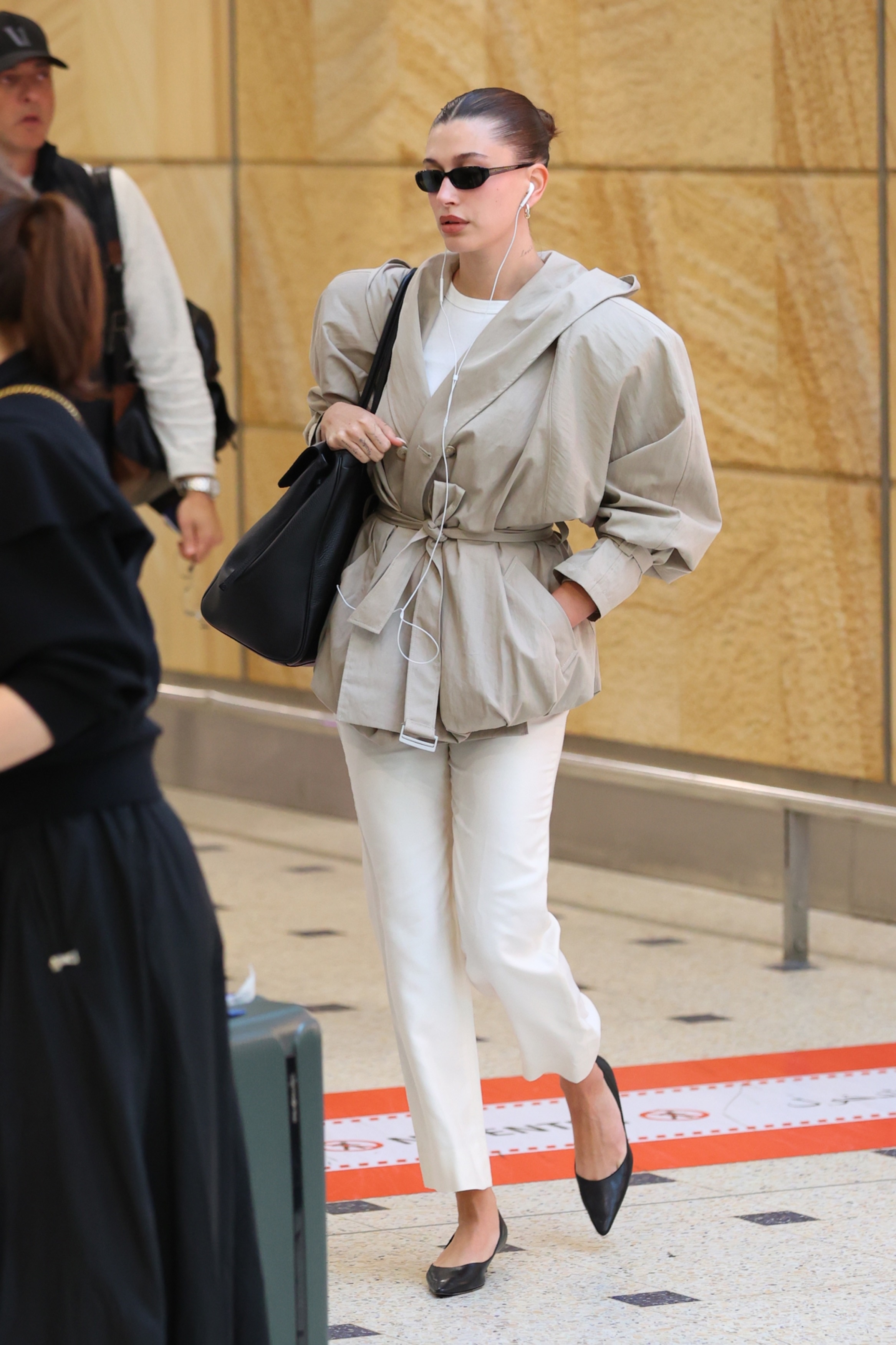 An image of Hailey Bieber wearing a cropped trench from Magda Butrym and shoes and trousers from The Row.