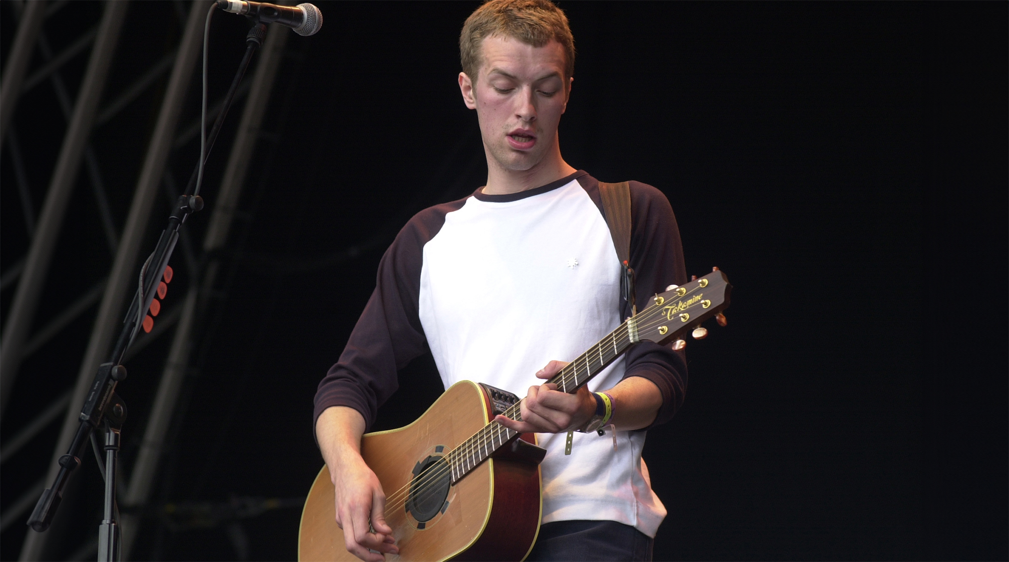 Chris Martin performing live onstage with Coldplay, playing acoustic guitar, at the Glastonbury Festival, June, 24, 2000