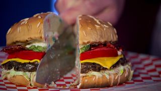 A knife slices a cake designed to look like a burger clean in half in the show Is it Cake?