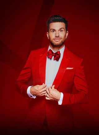 Joel Dommett wearing a red tuxedo with a red bow tie