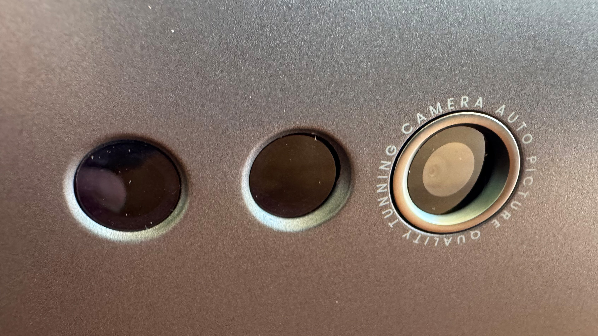 The BenQ W2720i projector, pictured on a wooden table in a living room