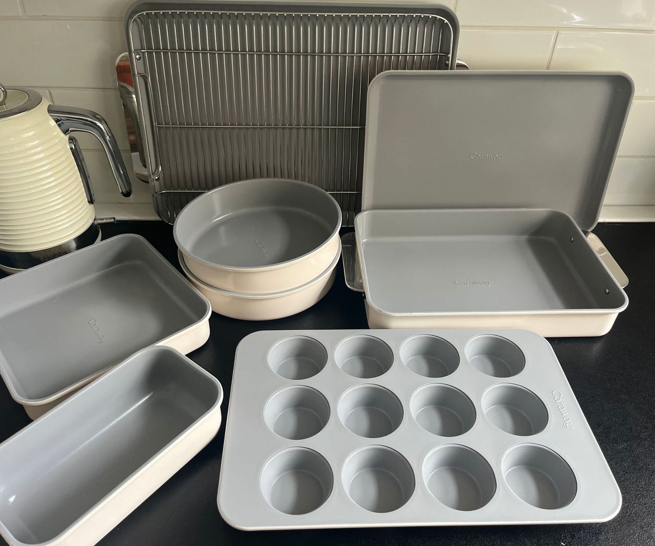 A collection of cream and grey bakeware on a black kitchen counter