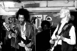 Jimi Hendrix (left) plays a right-handed bass guitar upside down during an onstage jam with Johnny Winter