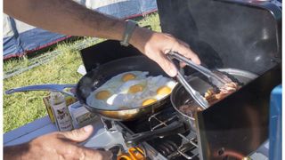 Cooking eggs and bacon on a gas camp stove