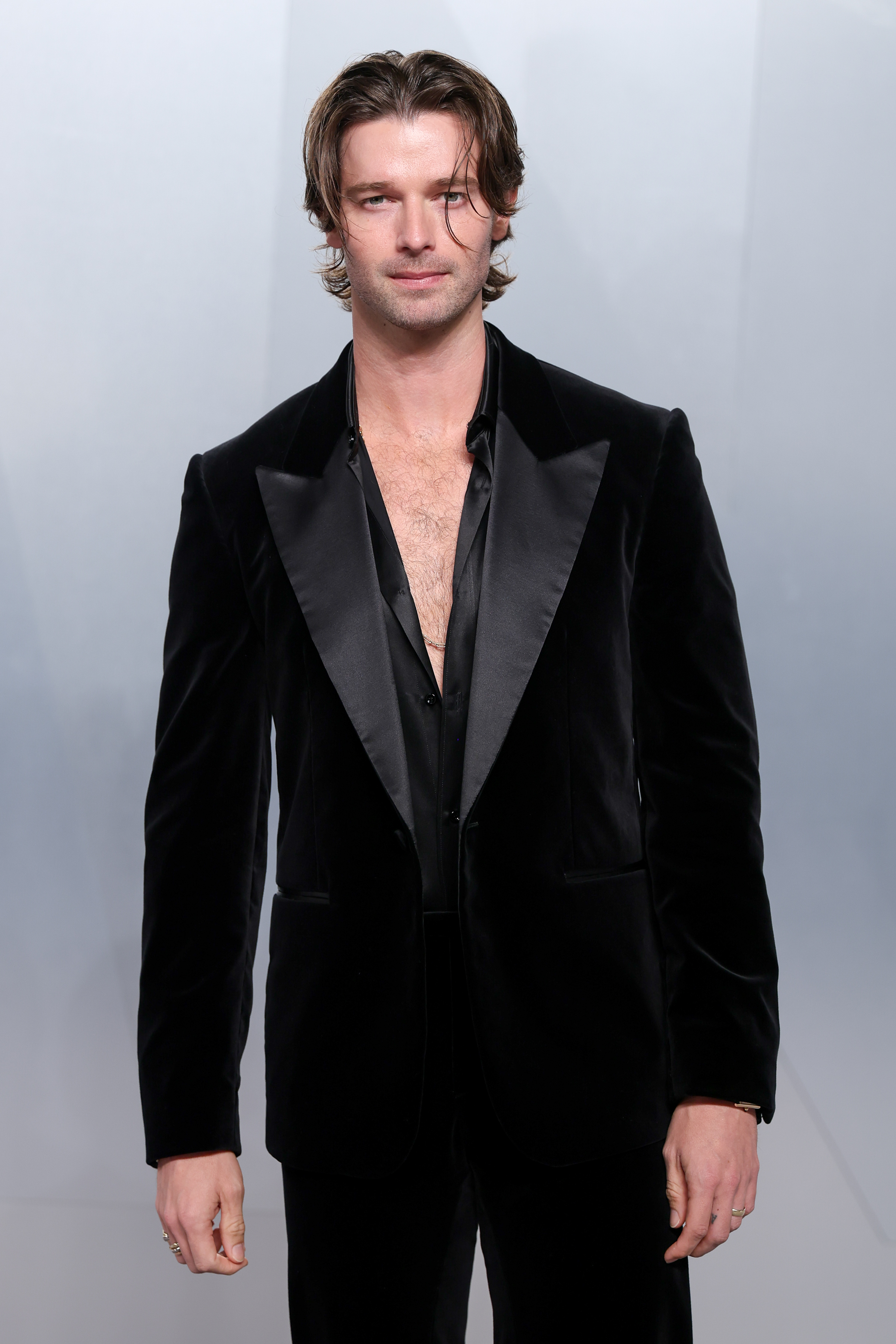Patrick Schwarzenegger wears a black velvet suit with a v neck shirt underneath as he atends at the 2026 Vanity Fair Oscar Party