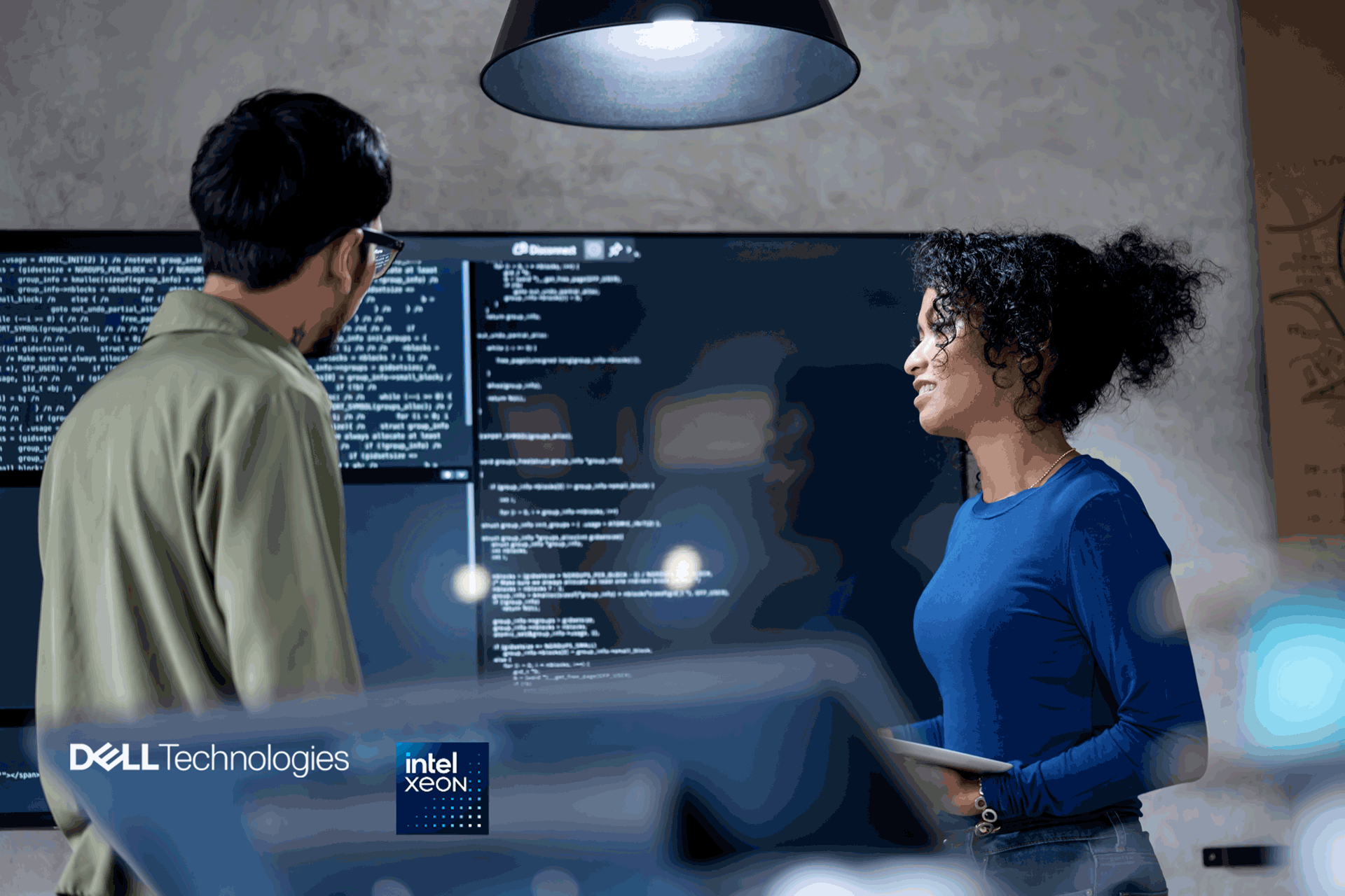 man and woman in front of screen in office