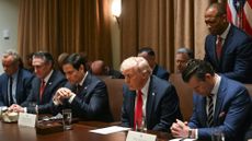 President Donald Trump prays alongside members of his Cabinet during a meeting.