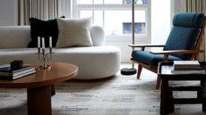 A living room with a textured carpet in muted tones