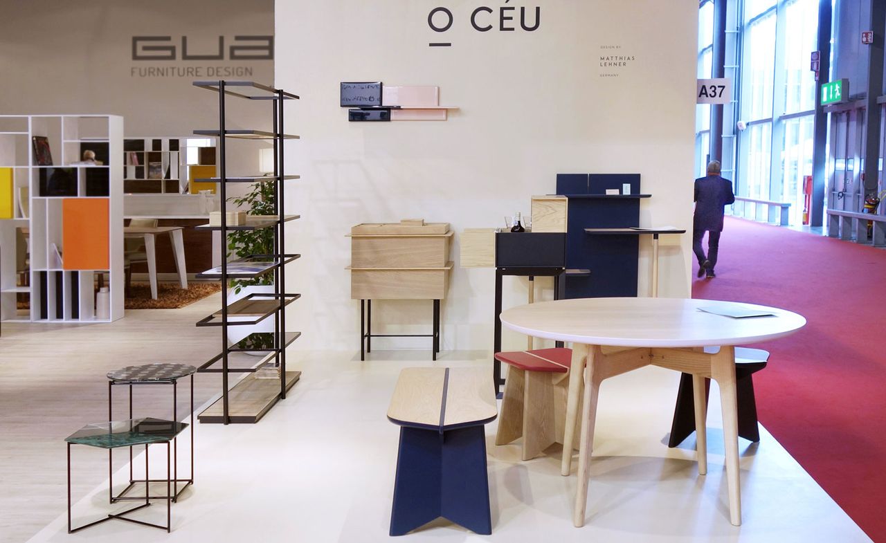 View of the O CÉU stand at the Salone del Mobile exhibition featuring multiple pieces of furniture