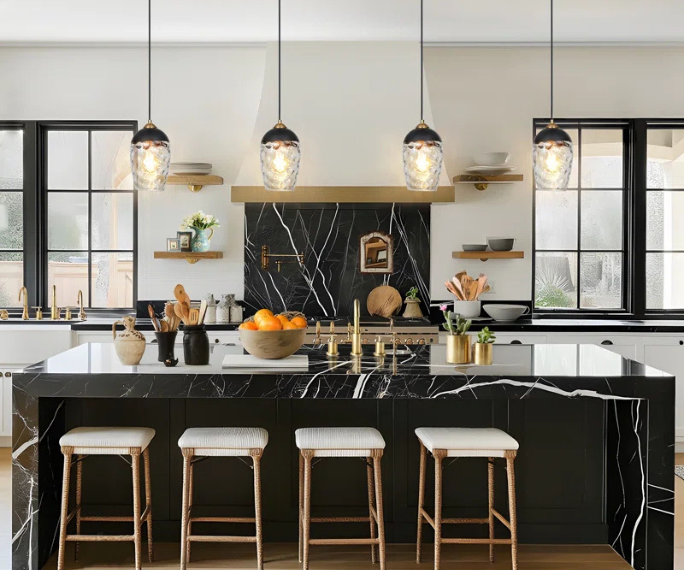 A white and black marble kitchen with hammered glass pendant lights