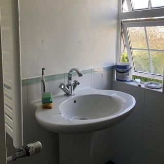 bathroom with white sink and white wall