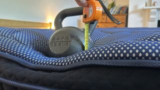 A weight resting on the edge of the DreamCloud Luxe Memory Foam mattress to measure edge support