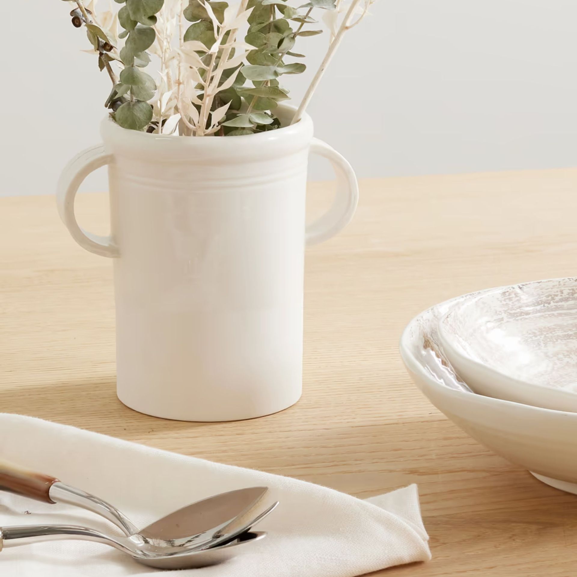 A white ceramic vase on a dining table