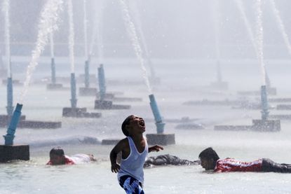 A child plays underneath water cannons in Queens, New York.