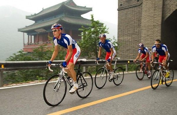 The French team rides past a shrine