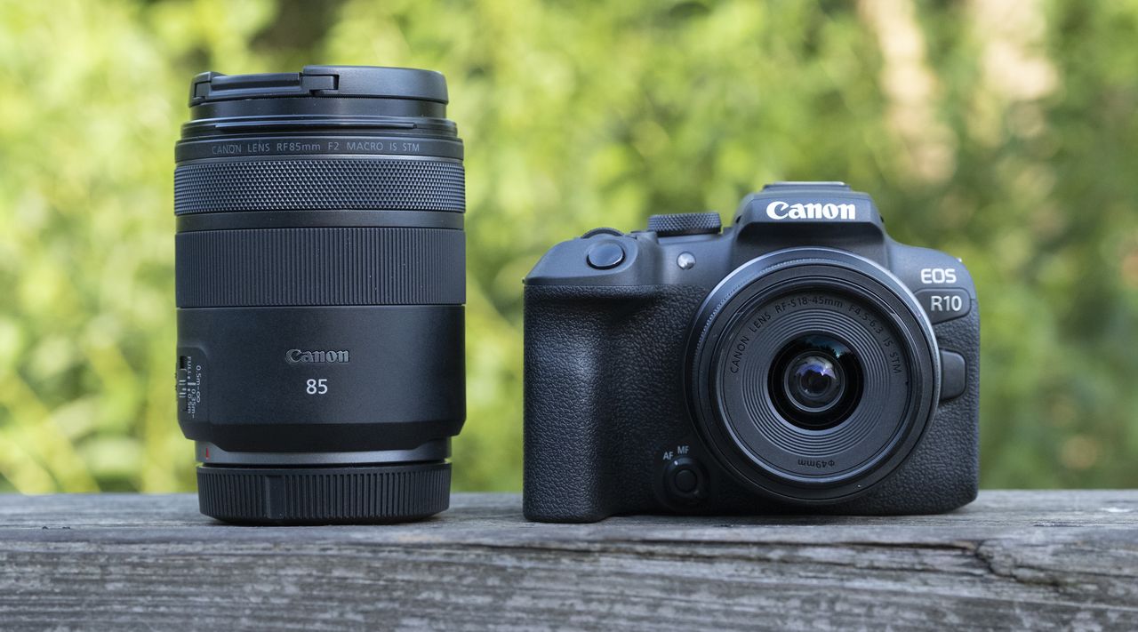 The Canon EOS R10 camers sitting on a wooden bannister