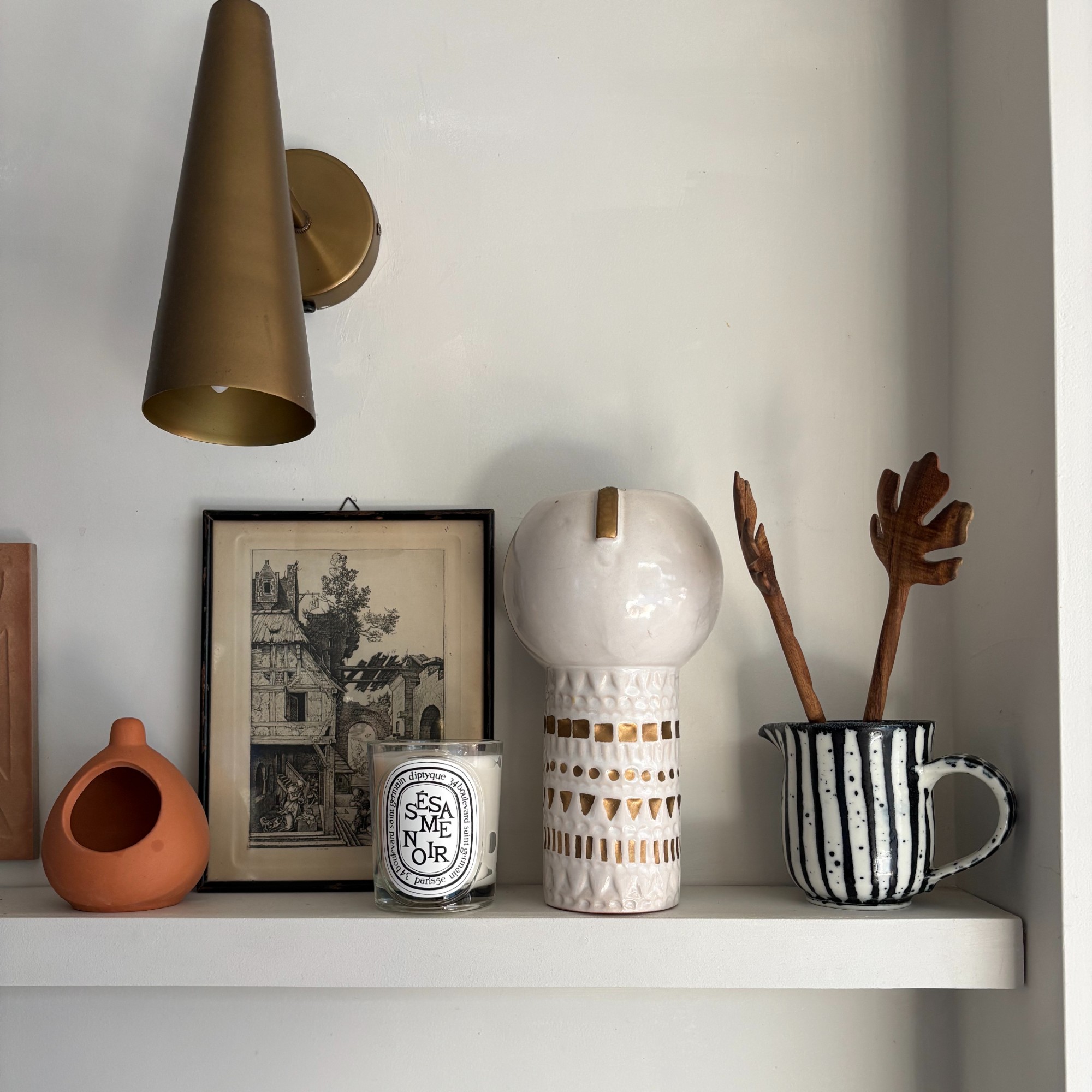 Heather Young's kitchen shelf displaying decorative items along with Diptyque's Sesame Noir candle