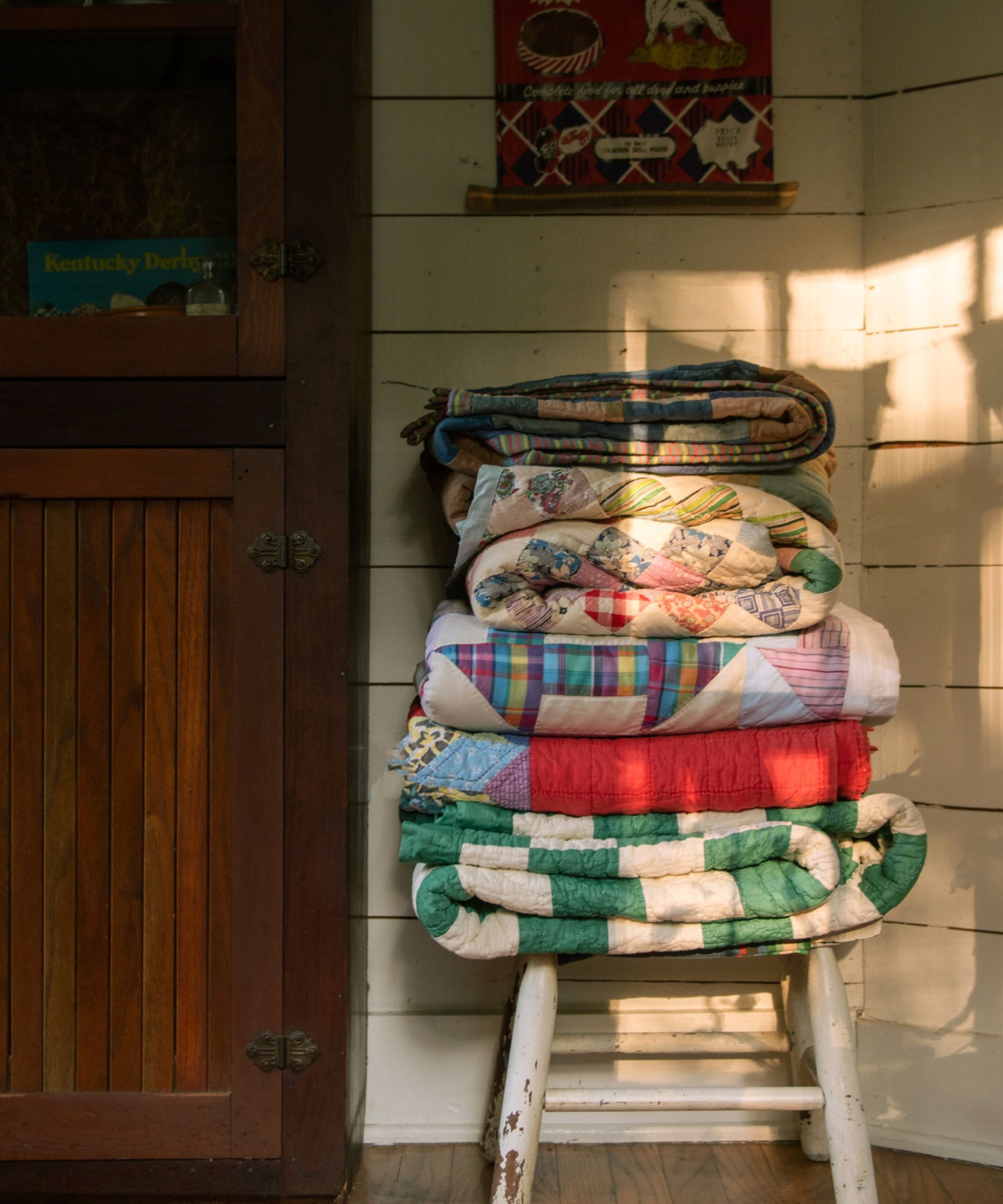 Patchwork quilt collection piled on a chair