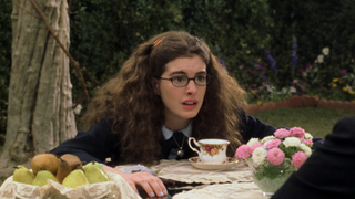 Anne Hathaway as Mia Thermopolis leaning over a table at tea in The Princess Diaries