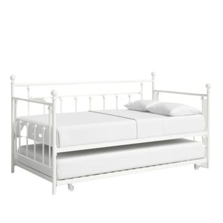 A white daybed with a metal frame and mattress