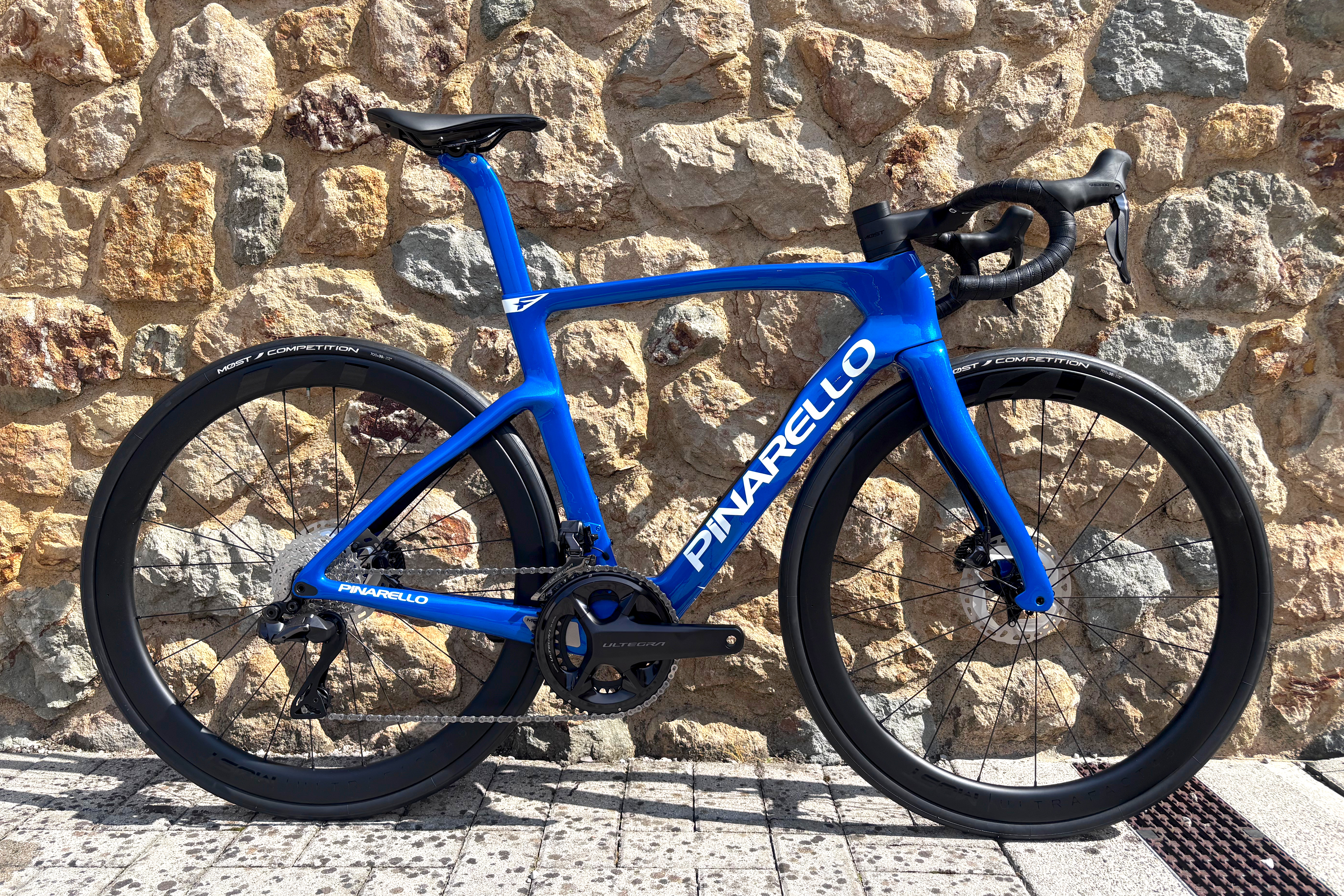 Blue Pinarello race bike against italian stone wall