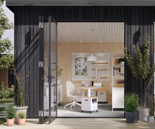 garden studio with white office furniture shown through open doors
