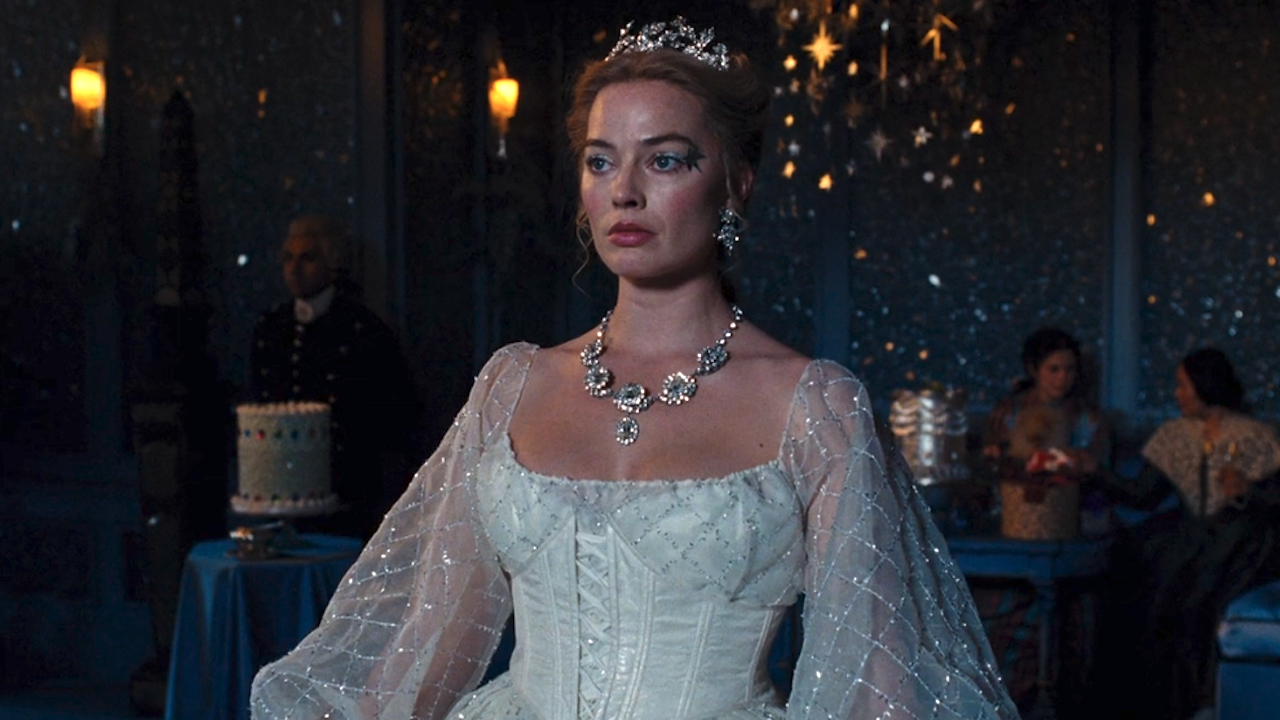 Margot Robbie in a sparkly white dress, a large silver necklace and crown in Wuthering Heights