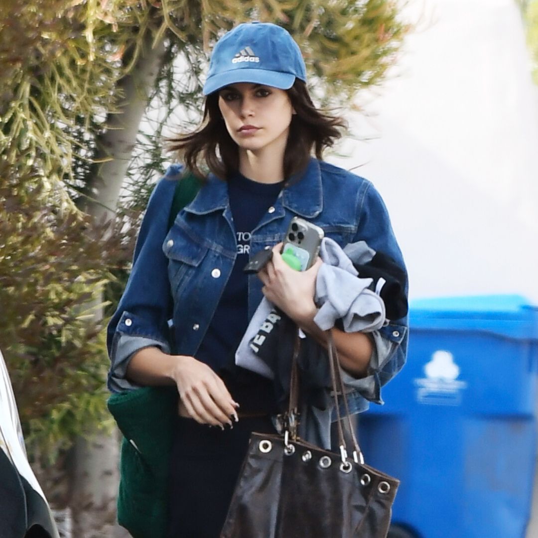 Kaia Gerber walking in Los Angeles in a jean jacket and studded tote