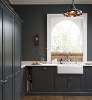 dark grey small kitchen with white worktops by deVOL