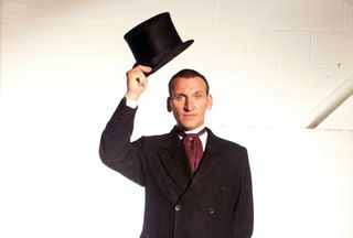 christopher eccleston holds up a top hat as Doctor Who