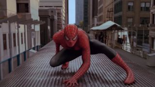 Spider-Man in a superhero pose, on top of a moving train, in Spider-Man 2.