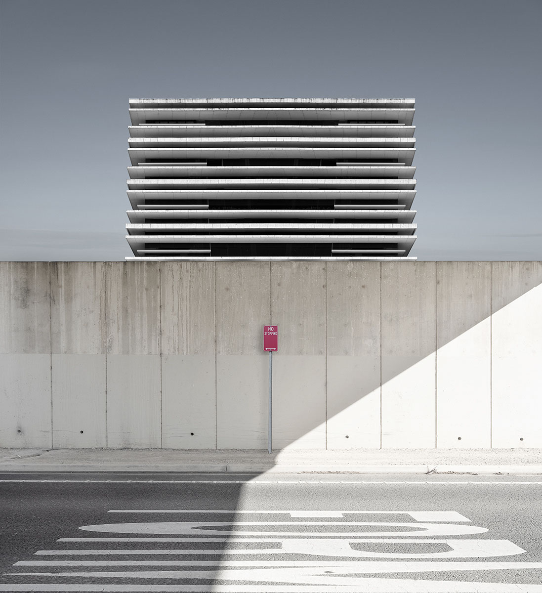 A road and wall in front of a modern building