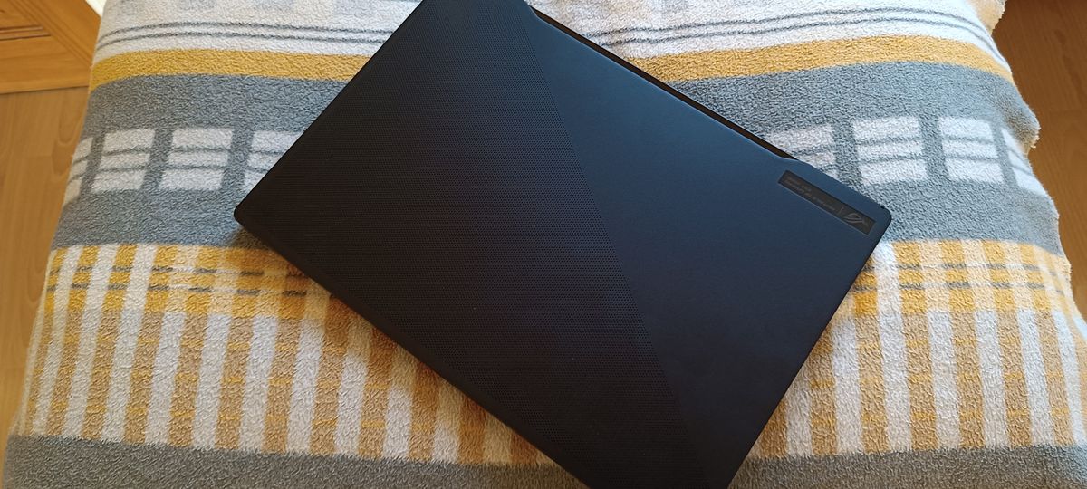 An ASUS ROG Zephyrus M16 gaming laptop sitting on a rug