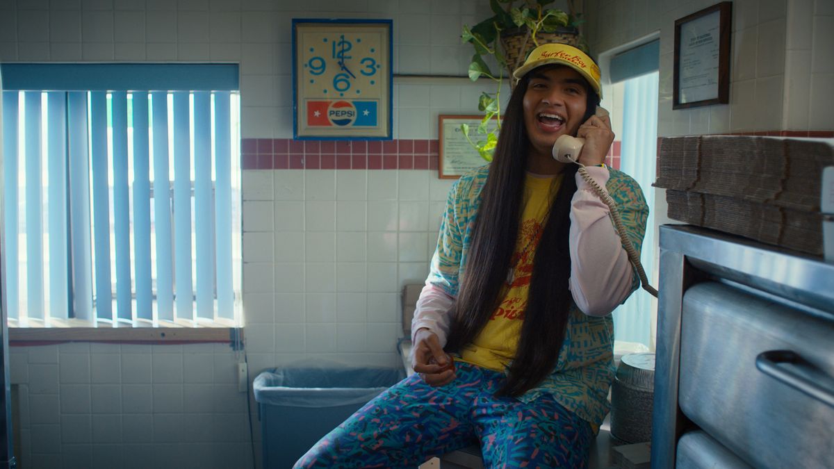teenager sitting on a counter and on the phone in Stranger Things