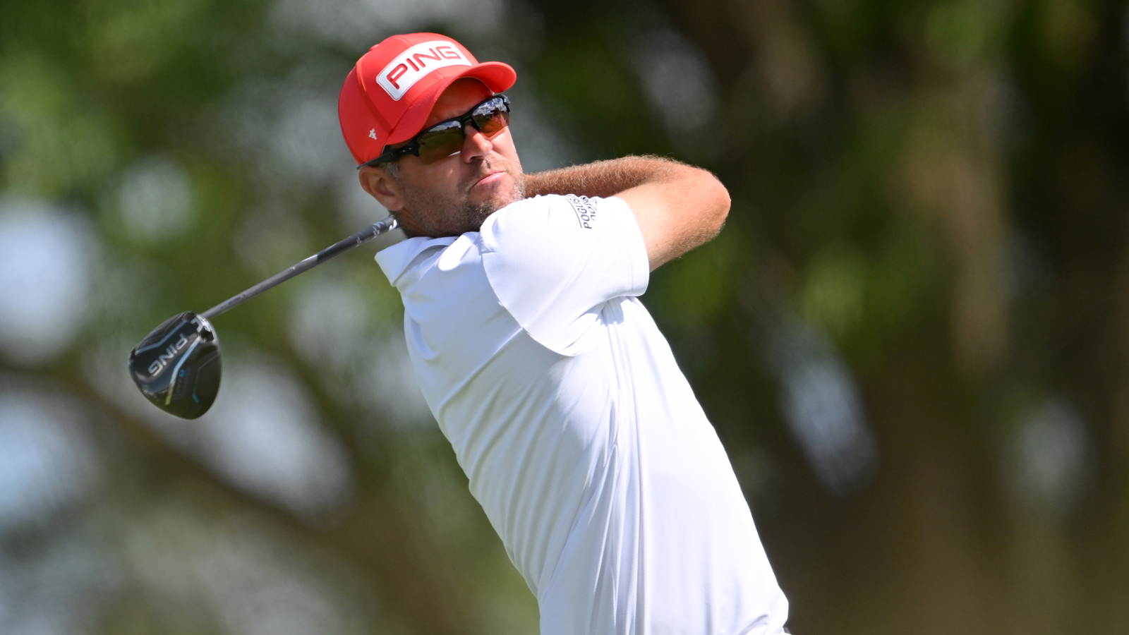 Corey Conners hits a driver off the tee and watches the flight
