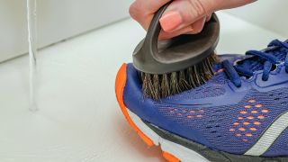 Running shoe upper being cleaned with a stiff brush