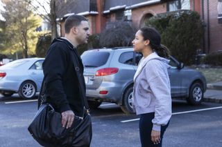 Josh Rivera as Aaron Hernandez and Jaylen Barron as Shayanna Jenkins, talking to each other in a residential parking lot, in 'American Sports Story: Aaron Hernandez.'