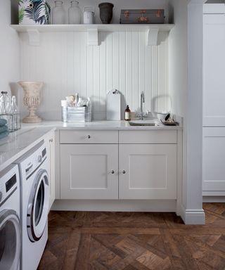 White laundry room scheme with rich wood flooring contrast