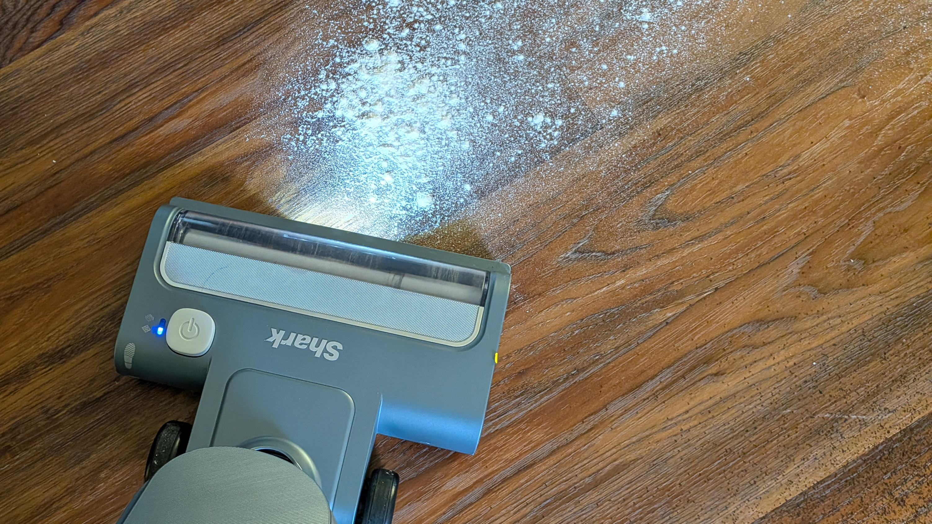 Tester using the Shark Freestyle Max cordless upright vacuum to clear flour from a hard floor