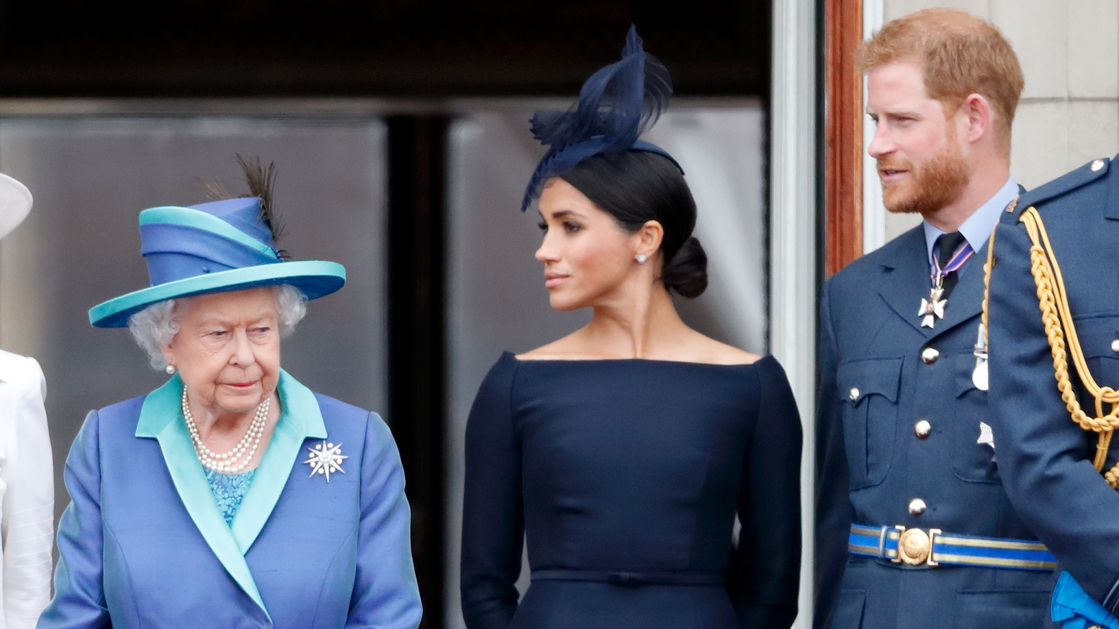 Queen Elizabeth II, Meghan, Duchess of Sussex and Prince Harry, Duke of Sussex watch a flypast to mark the centenary of the Royal Air Force from the balcony of Buckingham Palace on July 10, 2018