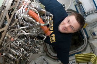 NASA astronaut Doug Wheelock in 2010 with Sabatier, a system that creates water from byproducts of the International Space Station's oxygen-generation system and carbon dioxide removal assembly.