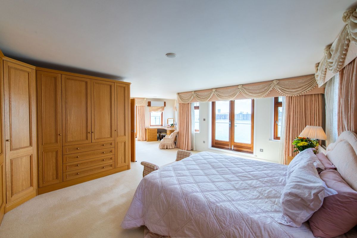 Bedroom with bifold doors leading to the balcony and also has wooden cabinets and cupboards in built into the room