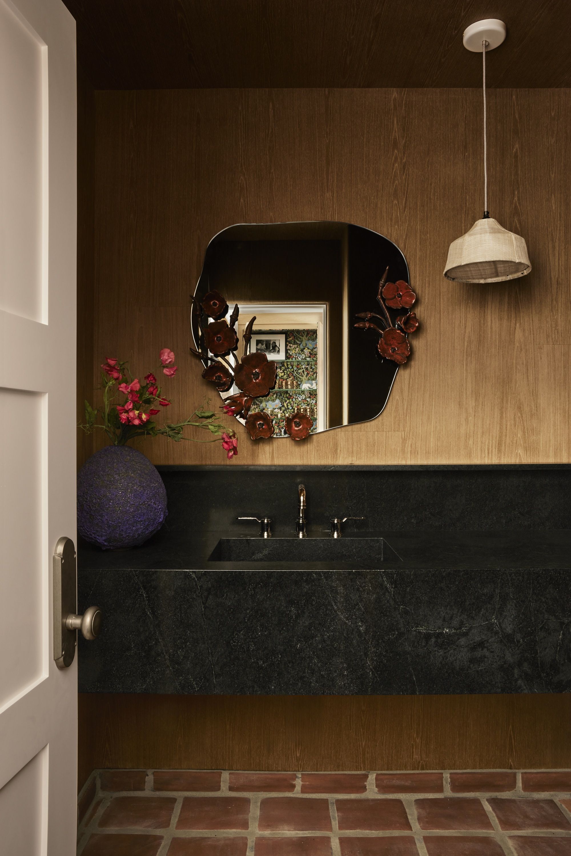 a bathroom with timber panelling and a mirror with floral motifs