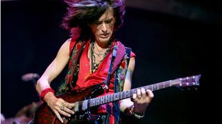 Joe Perry plays a Schecter doublecut electric guitar onstage in 2012