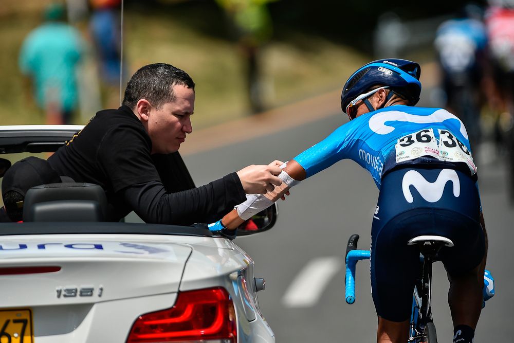 Movistar's Team Colombian cyclist Nairo Quintana (R) receives medical attention as he competes during the third stage of the 'Colombia Oro y Paz