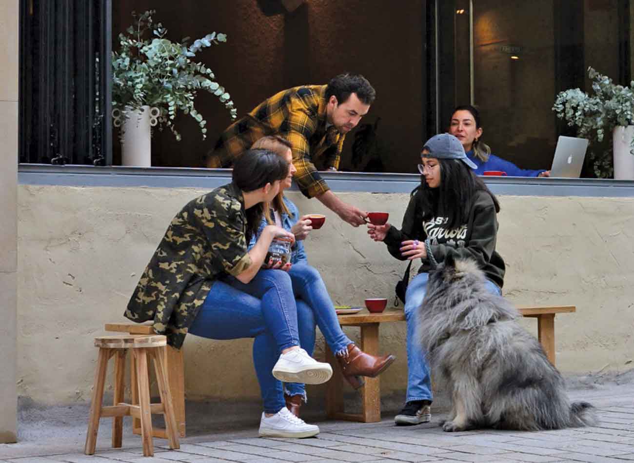 Roots owner Oleg Buyalo (centre) serving wine to customers sitting outside