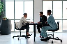 Elegant financial advisor during a meeting with clients in a modern office